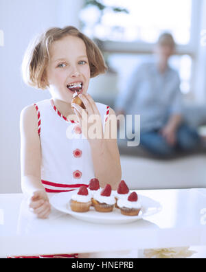 Young girl eating cup cake Stock Photo