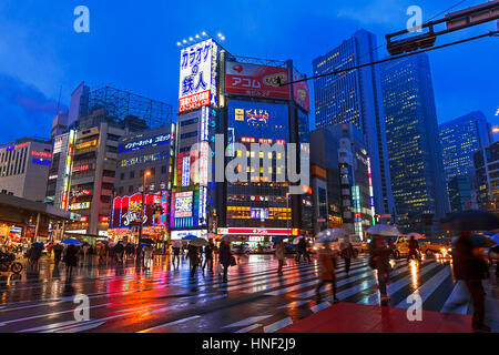 TOKYO - March 2 : Pedestrians crossing Yasukuni Dori on a rainy evening in Tokyo on 2nd March 2012. Yasukuni is a busy shopping and sightseeing street Stock Photo