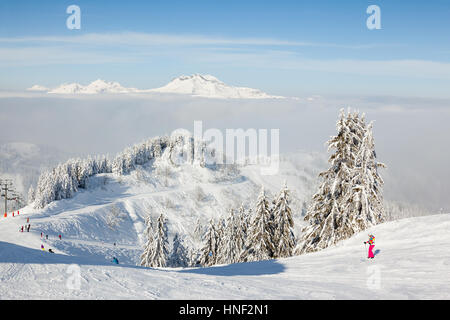MORZINE, FRANCE - FEBRUARY 06, 2015: Skiers and snow boarders on Le Ranfoilly mountain peak in Les Gets ski resort in the Portes du Soleil ski area. Stock Photo