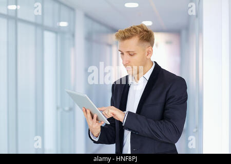 A man in  suit works with the tablet  office corridor Stock Photo