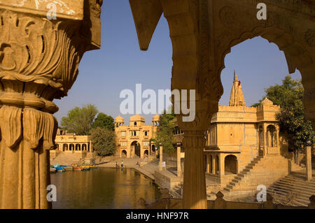 Gadi Sagar, the tank was once the water supply of the city and is surrounded by small temples and shrines,in background  Tilon ki Pol archway,Jaisalme Stock Photo
