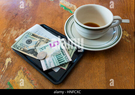 Receipt and cash and an empty coffee cup Stock Photo