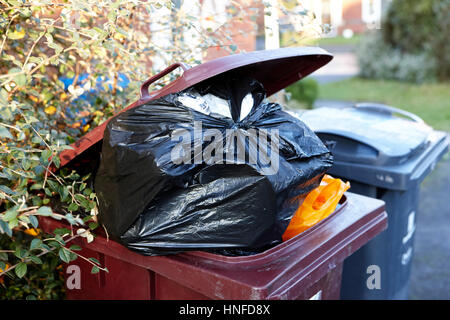 overflowing wheelie bin lid open rubbish waste bin liverpool uk Stock Photo