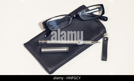 The leather black cover, glasses and pen. White isolated background. Stock Photo