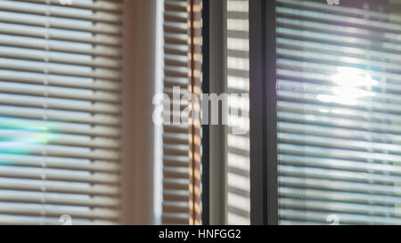 The sun shining through the blinds and are reflected in the window Stock Photo