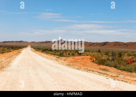 Long white gravel dirt road in outback landscape, Pilbara, Western Australia. Stock Photo