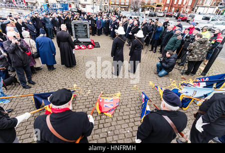 Memorial service to commemorate the 75th anniversary of Operation Fuller when the British tried to stop Germany Heavy Cruisers during the Channel Dash in world war two. People, veterans and dignitaries gathered around memorial stone during remembrance ceremony. Lowed standards in foreground. Stock Photo