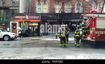 New York City, USA. 12th February, 2017. FDNY firefighters waiting in the rain on West 3rd Street. New York has been under storm clouds all weekend. Credit: Ward Pettibone/Alamy Live News Stock Photo