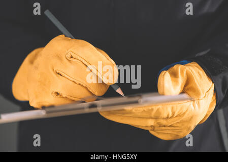 Building, developing, construction and architecture concept - engineer writing in notepad, close up of hands in protective gloves Stock Photo