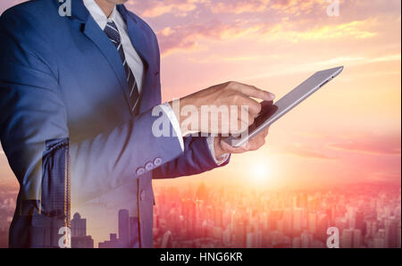 Businessman with digital tablet on blurred city background Stock Photo
