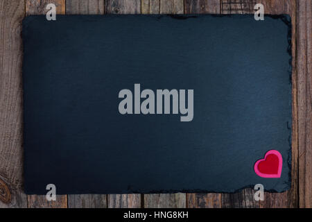 Valentine's Day stone board background with hearts on wood. Flat lay, top view. Stock Photo