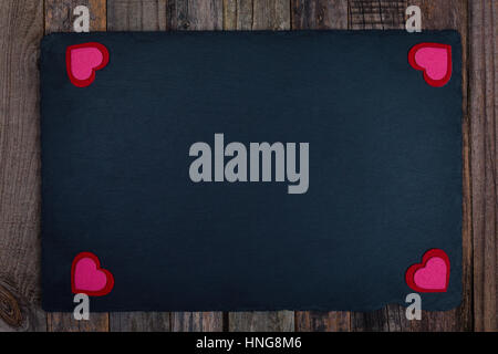 Valentine's Day stone board background with hearts on wood. Flat lay, top view. Stock Photo