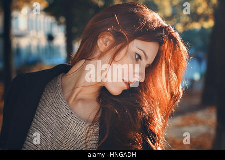 Autumn portrait of a beautiful red haired woman. City and urban Stock Photo