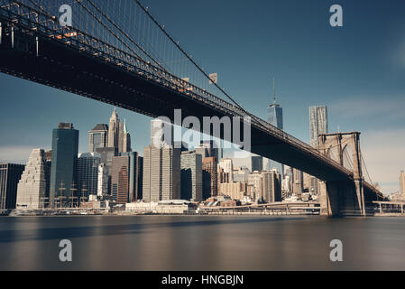 Below Brooklyn Bridge with downtown Manhattan skyline in New York City Stock Photo