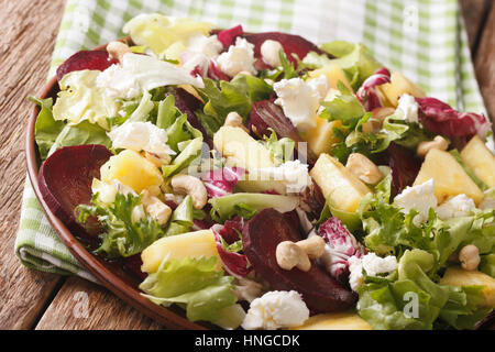 Dietary food: salad of beets, pineapple, cream cheese, cashews and greens closeup on a plate. horizontal Stock Photo