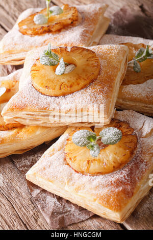 puff pastry pies with pineapple, decorated with mint close up on the table. vertical Stock Photo