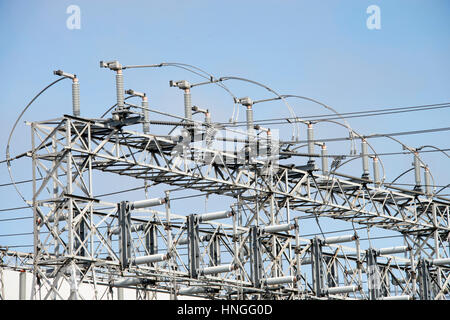 Power station coils and wires against a blue lightly cloudy sky. Stock Photo