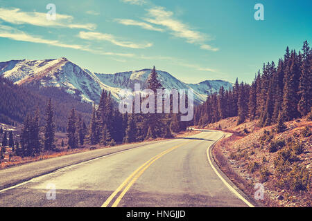 Retro color toned Rocky Mountains road, Colorado, USA. Stock Photo