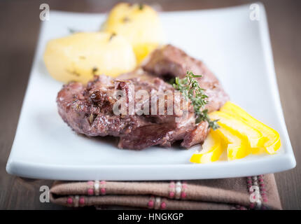 Rabbit meat with wine sauce served on a white plate Stock Photo