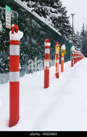 Red warning posts in a deserted parking lot with heavy snow Stock Photo