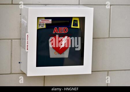 An automated external defibrillator (AED) on the wall of a school Stock Photo