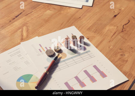 coin, pen and business document on wooden table, selective focus and vintage tone Stock Photo