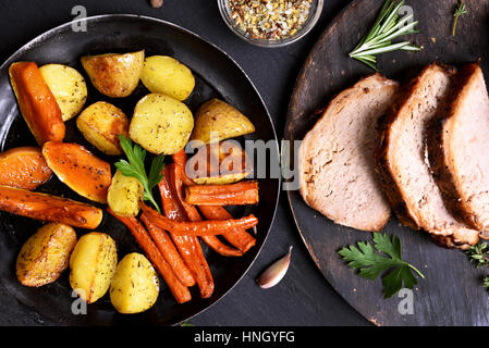 Fried vegetables in frying pan and sliced grilled meat, top view. Focus on vegetables Stock Photo