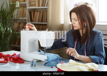 Lovely seamstress at the table Stock Photo