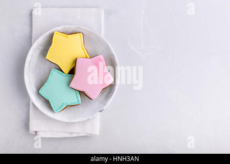 Star shaped cookies in three various colors on plate shot from above Stock Photo