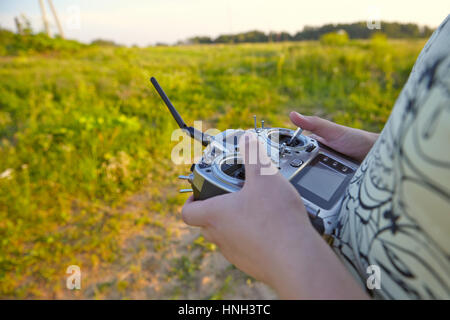 Remote control for quadrocopter, close-up. Transmitter for controlling moving device in male hands, blurred nature background. Electronics, hobby, aer Stock Photo