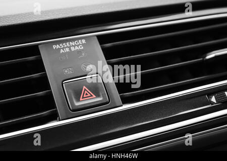 Emergency stop button with red tiangle sign, modern black car interior details Stock Photo
