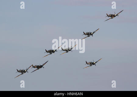 Seven Spitfires of various marks and including several two-seat conversions with a formation flypast at a Duxford airshow. Stock Photo