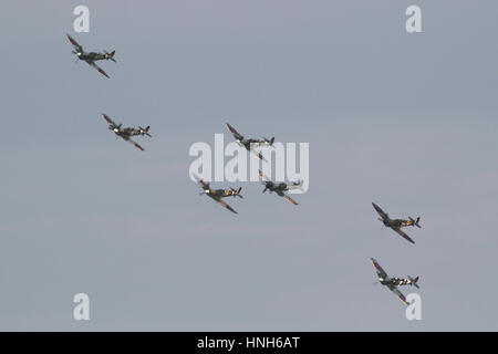 Seven Spitfires of various marks and including several two-seat conversions with a formation flypast at a Duxford airshow. Stock Photo