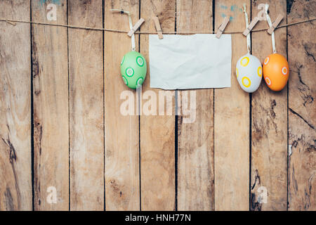 easter egg and blank paper for label hanging on wood background with space. Stock Photo