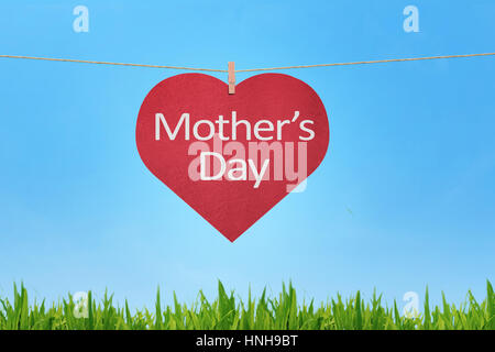 Happy Mothers Day message written on red heart shaped gift tags hanging against a skyline background Stock Photo