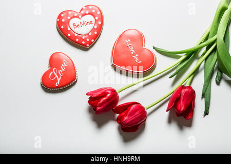 Flowers tulips and heart shaped gingerbread cookie. Concept the Feast Day of Holiday Valentine's Day, Mother's day. Stock Photo