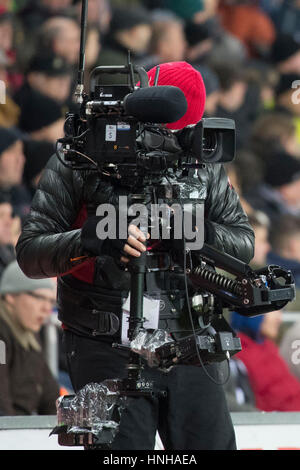 A TV cameraman uses a steadycam at a sporting event. Stock Photo