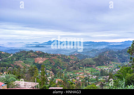 The picturesque mountains of Sri Lanka, covered with morning fog, hides the tiny villages, towns, tea estates, Boragasketiya. Stock Photo