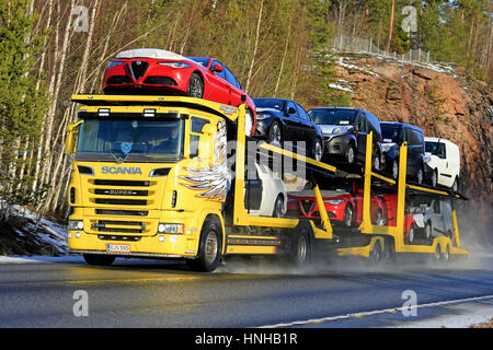 KARJAA, FINLAND - JANUARY 22, 2017: Yellow Scania R500 car carrier truck hauls a load of new vehicles on along highway in winter. Stock Photo