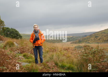 A woman hiking through Dartmoor National Park Stock Photo