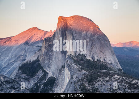 Classic view of famous Half Dome illuminated in beautiful golden evening light at sunset on a sunny day with blue sky, Yosemite National Park, USA Stock Photo