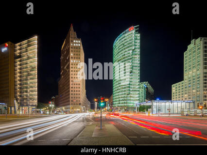 Long exposure view of famous Potsdamer Platz with illuminated skyscrapers and blurred motion light trails of moving cars at night, Berlin Mitte Stock Photo