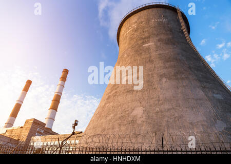 Chimney towers of the power plant on the sky background Stock Photo