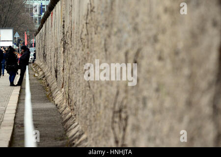 Pedestrian walk by the remnants of the Berlin wall at the memorial site Topography of Terror in Berlin, germany, 12 February 2017. Photo: Maurizio Gambarini/dpa Stock Photo