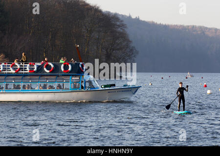 Cumbria, UK. 13th Feb, 2017. UK Weather. Lake Windermere cold sunny clear day with snow on the fells, Half Term, boy enjoys paddle boarding . Credit: Gordon Shoosmith/Alamy Live News Stock Photo
