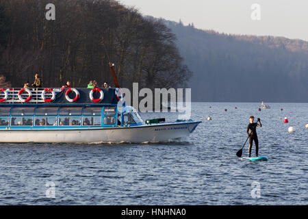 Cumbria, UK. 13th Feb, 2017. UK Weather. Lake Windermere cold sunny clear day with snow on the fells, Half Term, boy enjoys paddle boarding . Credit: Gordon Shoosmith/Alamy Live News Stock Photo