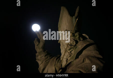 The moon can be seen behind the statue of Saint Kilian on the Alte Mainbruecke bridge in Wuerzburg, Germany, 13 February 2017. Photo: Karl-Josef Hildenbrand/dpa Stock Photo