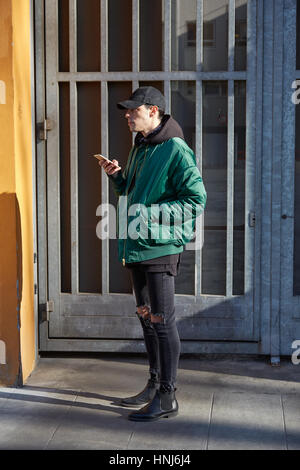 MILAN - JANUARY 17: Man with green bomber jacket before Giorgio Armani fashion show, Milan Fashion Week street style on January 17, 2017 in Milan. Stock Photo