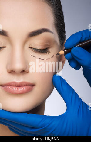 Doctor drawing line under eye Stock Photo