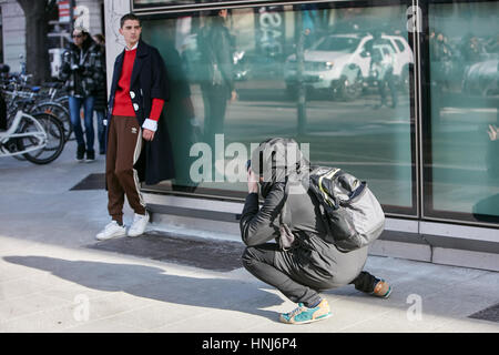 Photographer shooting pictures to a stylish man before Emporio Armani fashion show, Milan Fashion Week street style on January 14 Stock Photo